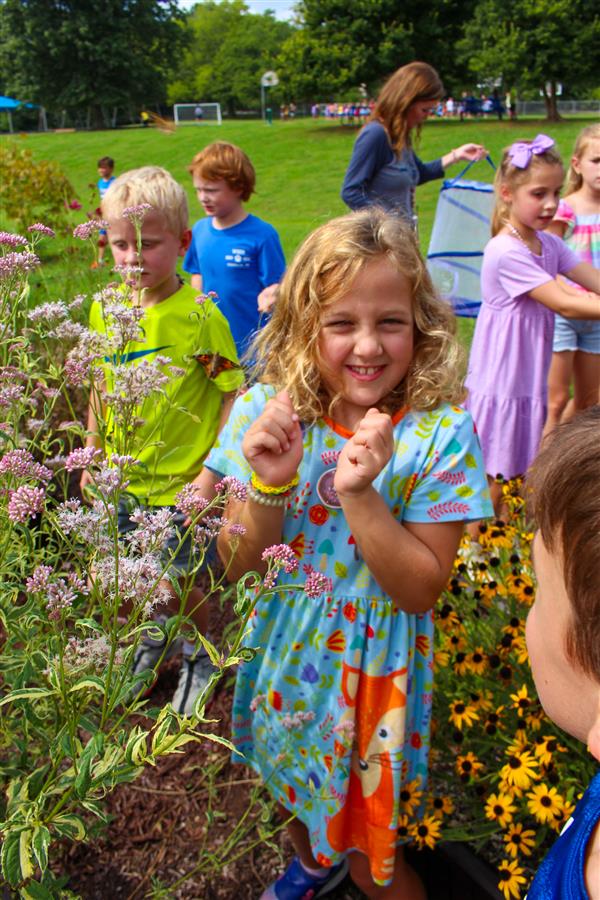 students in a flower garden with butterflies